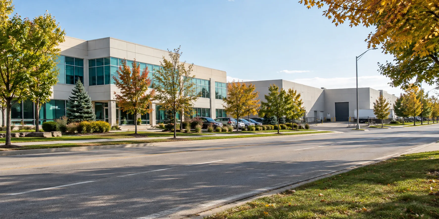 Tree-lined Burlington-style employment corridor with offices, light industrial buildings and a loading entrance